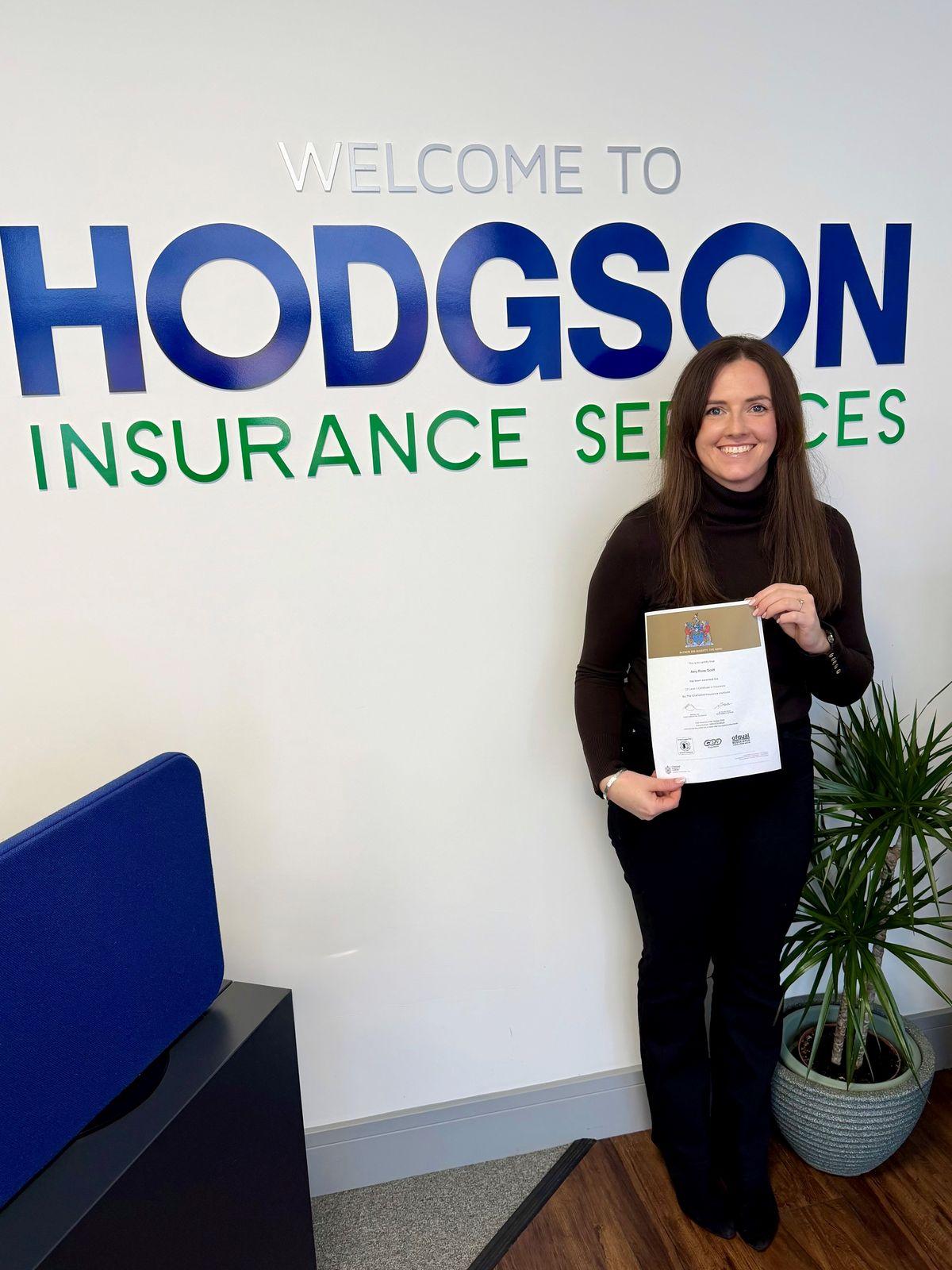 Amy Troke holding her CII certificate in our office